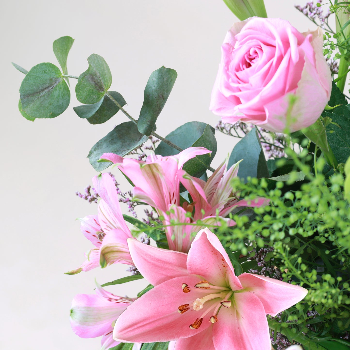 Bouquet Joli Bonheur avec lys roses et vase Harma en PLA suisse