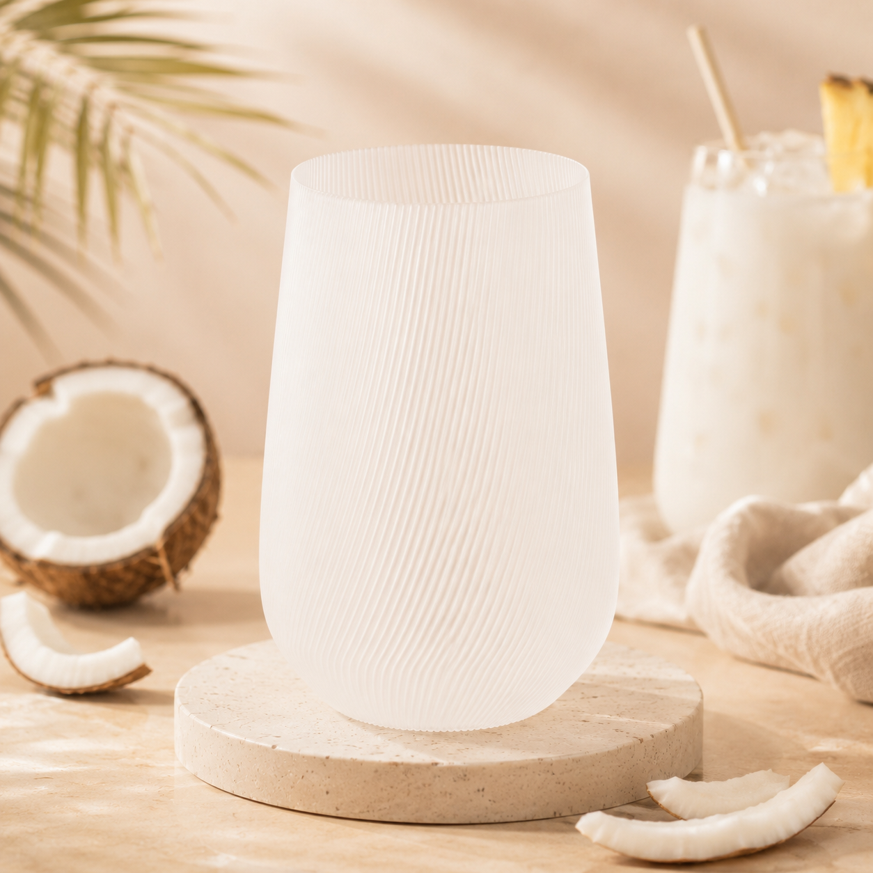 Vase Fjord Glow Coconut en bioplastique PLA blanc translucide avec rainures délicates, posé sur fond beige avec une noix de coco.

